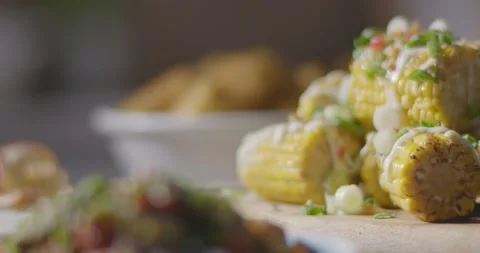 Loaded Herbs Chilli Onions Mayo Garnished Stack of Corn on the Cob Pan Right Video stock 161963860