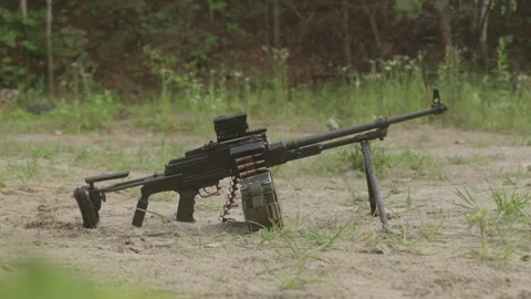 Loaded PKM machine gun on tripod resting on sandy ground Stock Footage 333612896