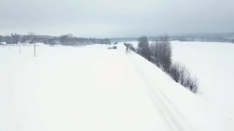 A loaded timber truck rides along a snowy road and carries logs in a trailer Stock Footage 101780901