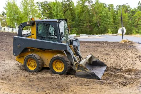 A loader with a bucket clears the site for construction Stock Photos