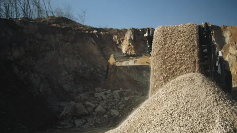 Loader bucket pouring stone pieces in crushing machine,rocks falling,quarry work Video stock 294063437