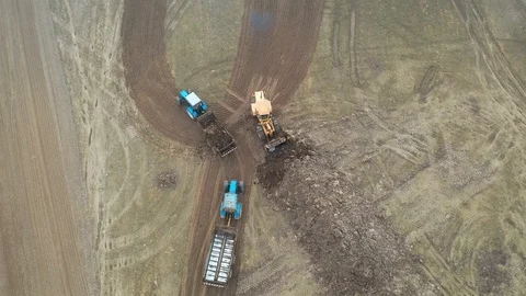 Loader Bucket Puts Fertilizer In Of Trailer Tractor To Handle Agricultural Field Video stock 106497862