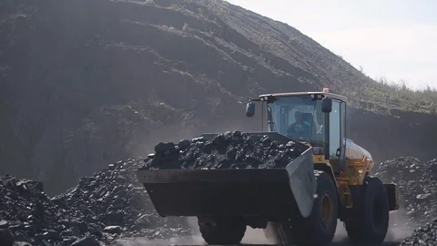 The loader carries coal in the bucket, about to load it into the truck 스톡 동영상 114818898
