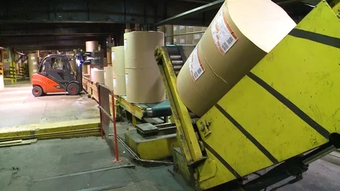 Loader carries rolls of paper in the warehouse of finished products. Stockbeeldmateriaal 105534996