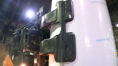Loader carries rolls of paper in the warehouse of finished products. Stockbeeldmateriaal 105535086