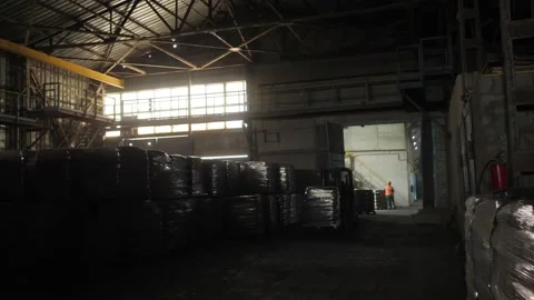 The loader driver loads and unloads pallets with bags in a very dark warehouse Stock Footage 156382507