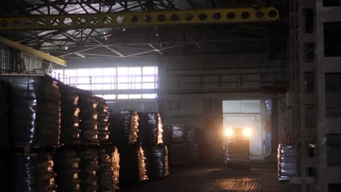 The loader driver loads and unloads pallets with bags in a very dark warehouse Stock Footage 156383051