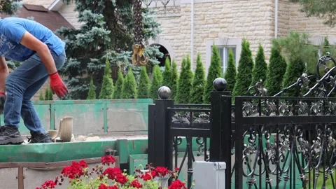 A loader helps a crane unload pallets of columns Stock Footage 284462279