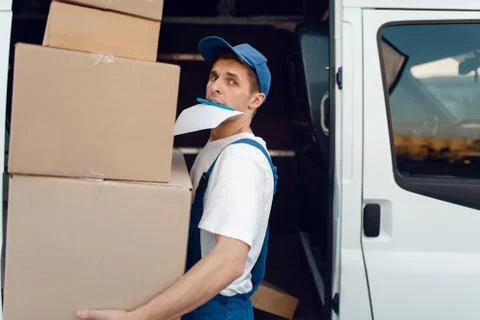 Loader holding stack of parcels, delivery service Stock Photos