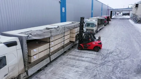 A loader is loading chipboard packages into the truck at the factory Stock Footage 169888464