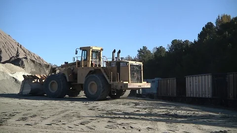 Loader loading granite aggregate or gravel into train car. Stock Footage 97960470