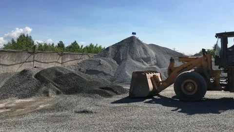 The loader loads the crushed stone into its bucket. Stock Footage 131434496