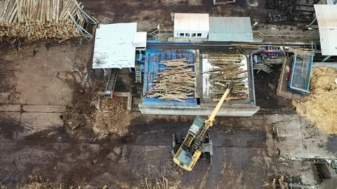 A loader loads logs at a wood processing factory from above from a drone Stock Footage 126081955