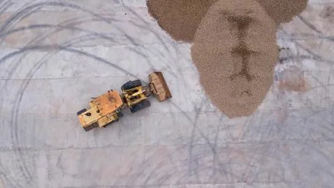 The loader loads the potatoes top view from the drone Stock Photos