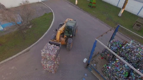 The loader loads the trailer with bales of compressed plastic. Aerial view. 4K Stock Footage 76492181