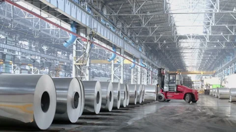 Loader machine rides by storage of aluminum rolls at workshop Stock Footage 32429481