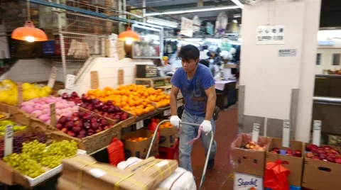 Loader man push cart with packages through aisle, indoor Bowrington Road market 動画素材 55575090
