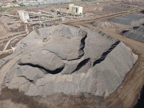 Loader moving rock crushing aggregate at quarry Stock Photos