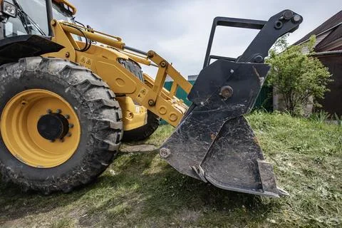 A loader is parked in a yard, ready to dig soil and lift materials. The machi 库存照片