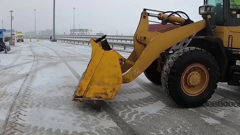 Loader picks up sand for construction work in snowy weather Stock Footage 124039723