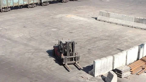 A loader at the port berth moves concrete blocks to form bulk cargo boundaries Stock Footage 120702584