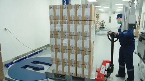 Loader in protective mask and uniform operates manually the cargo trolley at the Stock Footage 200855681