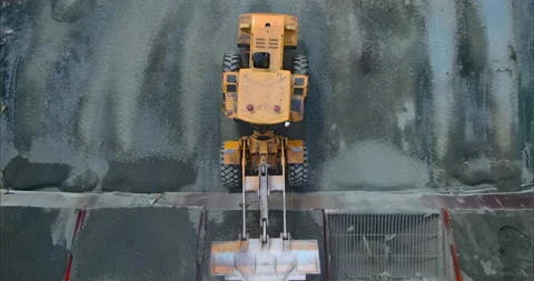 Loader unloads the asphalt from the bucket into a hopper or container. Unloading Stock Footage 158401583