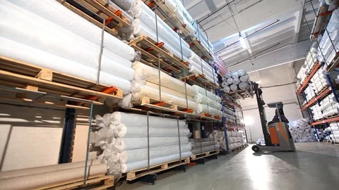 The loader unloads shelves with material rolls, storage of fabrics in the Видео 91537091