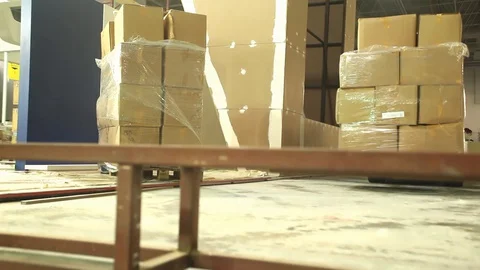 Loaders lift pallets with boxes in warehouse logistics center. Stock Footage 128929092