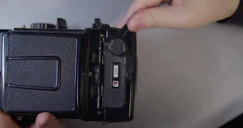 Loading a 120 film roll in a medium format camera using the lever mechanism. Stock Footage 317247588