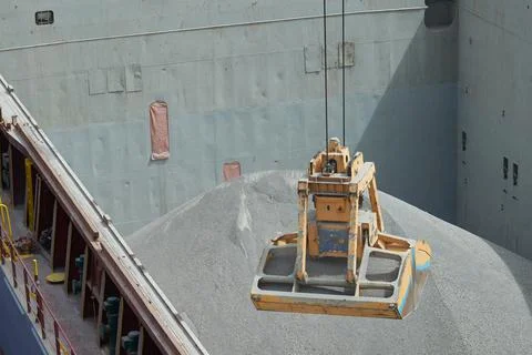 Loading and dischargind operation of bulk cargo bauxite on bulk carrier ship  Stock Photos