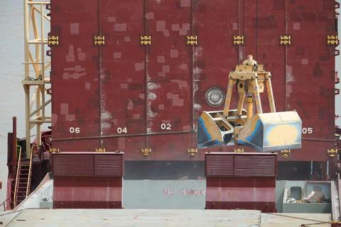 Loading and dischargind operation of bulk cargo bauxite on bulk carrier ship  Stock Photos