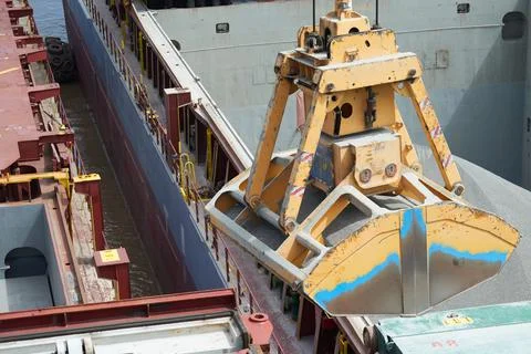 Loading and dischargind operation of bulk cargo bauxite on bulk carrier ship  Stock Photos