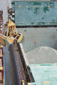 Loading and dischargind operation of bulk cargo bauxite on bulk carrier ship  Stock Photos