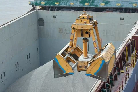 Loading and dischargind operation of bulk cargo bauxite on bulk carrier ship  Stock Photos
