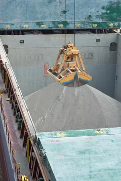 Loading and dischargind operation of bulk cargo bauxite on bulk carrier ship  Stock Photos