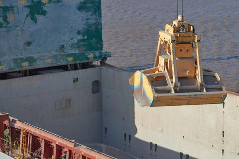 Loading and dischargind operation of bulk cargo bauxite on bulk carrier ship  Stock Photos