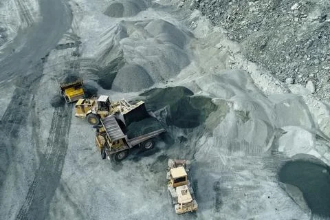 Loading and transportation of stone chips on dump trucks in quarry Stock Photos