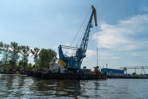Loading and unloading crane mounted on a small barge Stock Photos