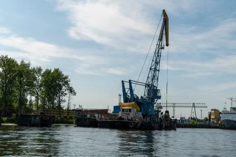 Loading and unloading crane mounted on a small barge Stock Photos