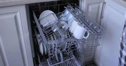 Loading the automatic dishwasher with dirty dishes Stock Footage 138642221