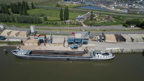 Loading barge with sand and rubble on a small berth. Freight transport logist Stock Photos