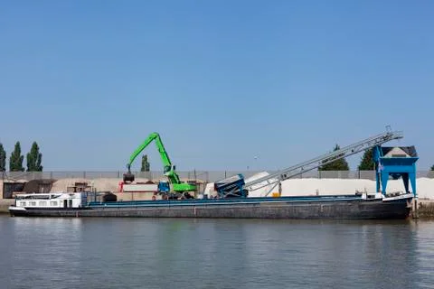 Loading barge with sand and rubble on a small berth. Freight transport logist Stock Photos