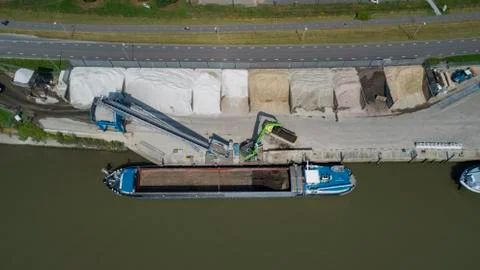 Loading barge with sand and rubble on a small berth Stock Photos
