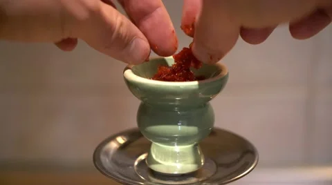 Loading the bowl of a hookah (shisha) pipe. Stock Footage 56294251