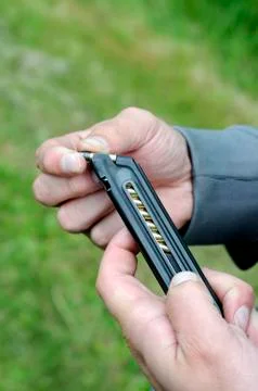 Loading bullets into pistol magazine Stock Photos