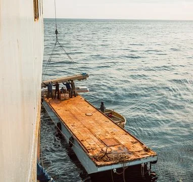 Loading cargo onto a barge from a box Foto stock