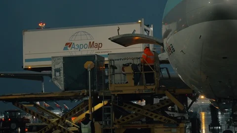 Loading cargo onto the plane with container loader Stock Footage 92727175