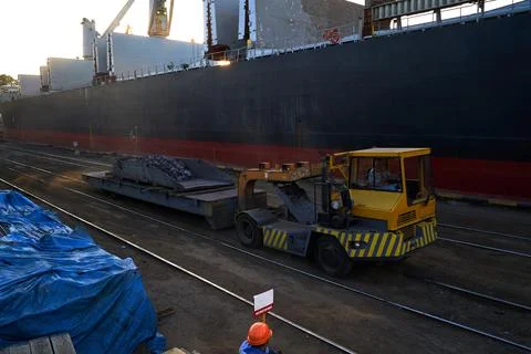 Loading cast iron ingots on ship bulk. Loading metal on ship. Industrial port Stock Photos