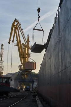Loading cast iron ingots on ship bulk. Loading metal on ship. Industrial port Stock Photos